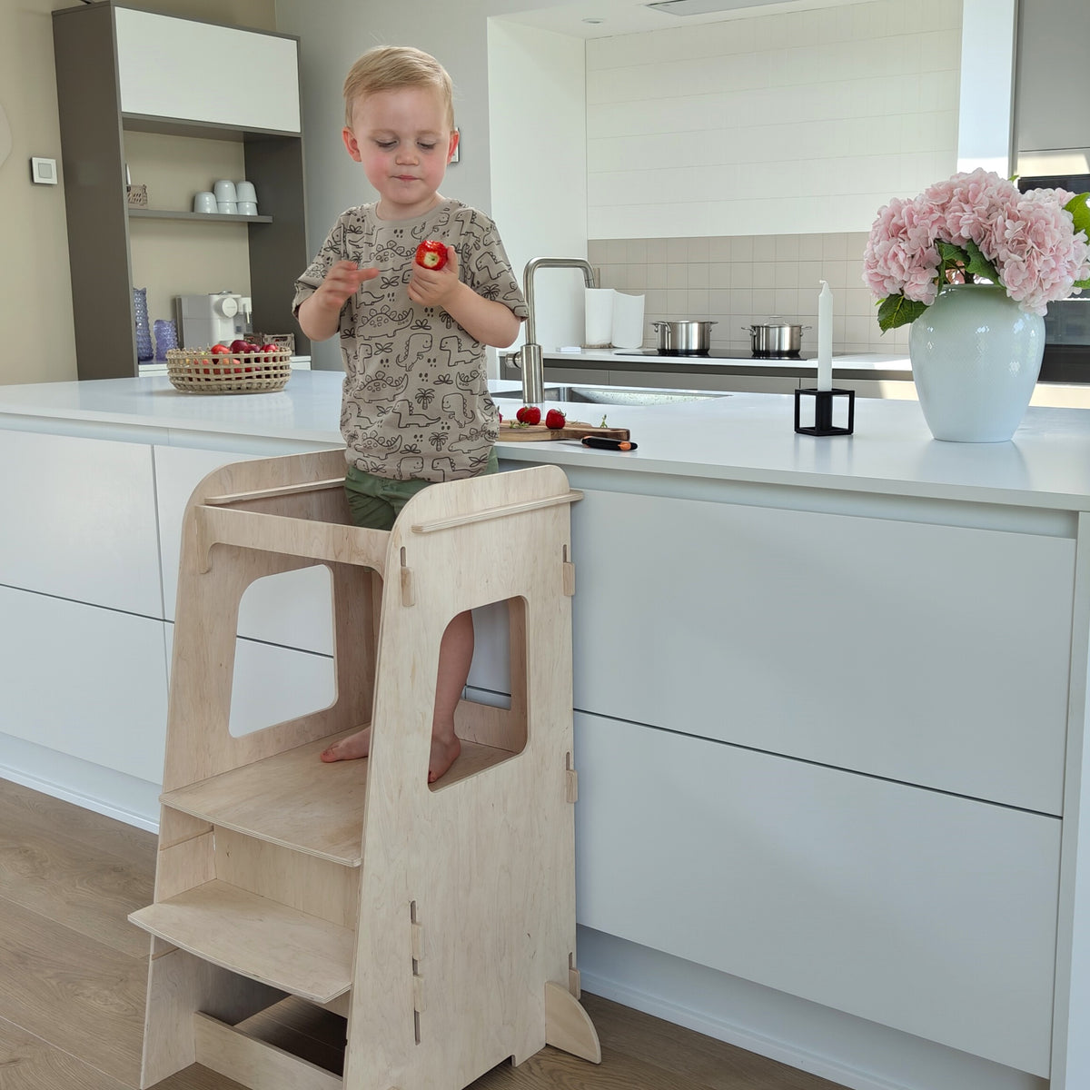 Læringstårn med glad barn i køkken