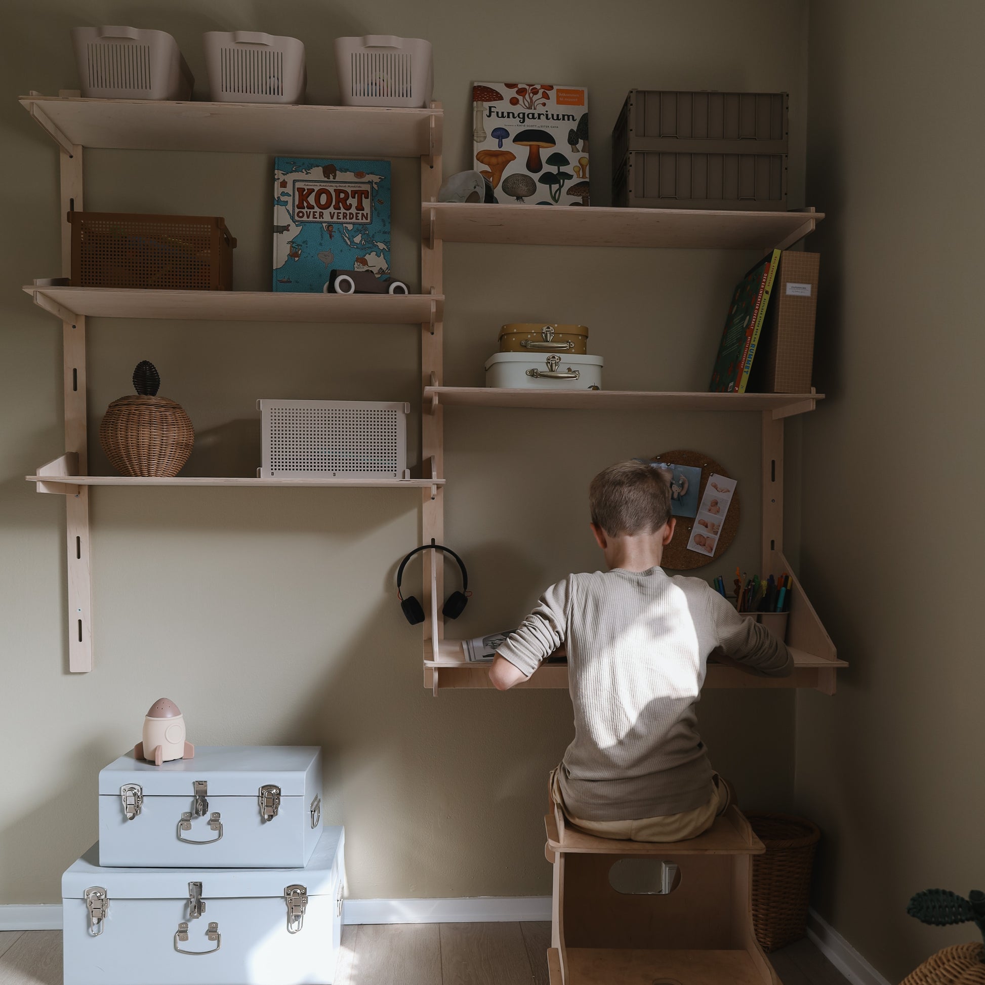 Dreng læser ved væghængt skrivebord til børn